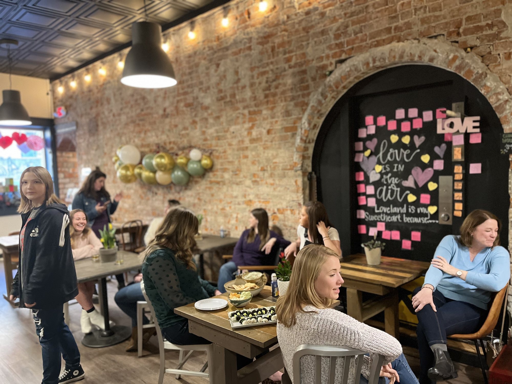 Inside Mile 42 Coffee: exposed brick, string lights and full tables